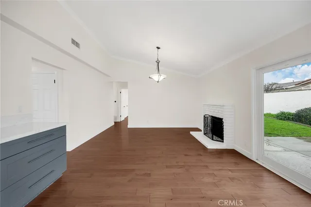 a view of an empty room with a fireplace and a window