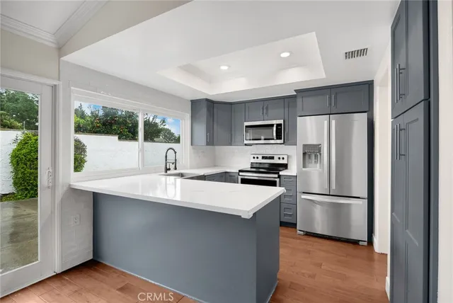 a kitchen with kitchen island a sink stainless steel appliances and cabinets