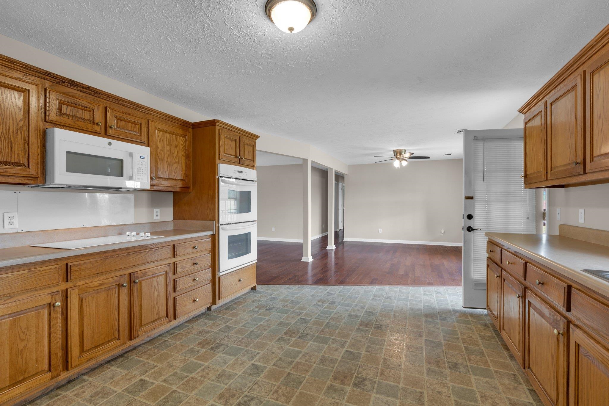 276 Mcbroom Road Henning, TN 38041 - Photo 13 of 36 Kitchen featuring dark wood-type flooring, white appliances, a textured ceiling, and ceiling fan