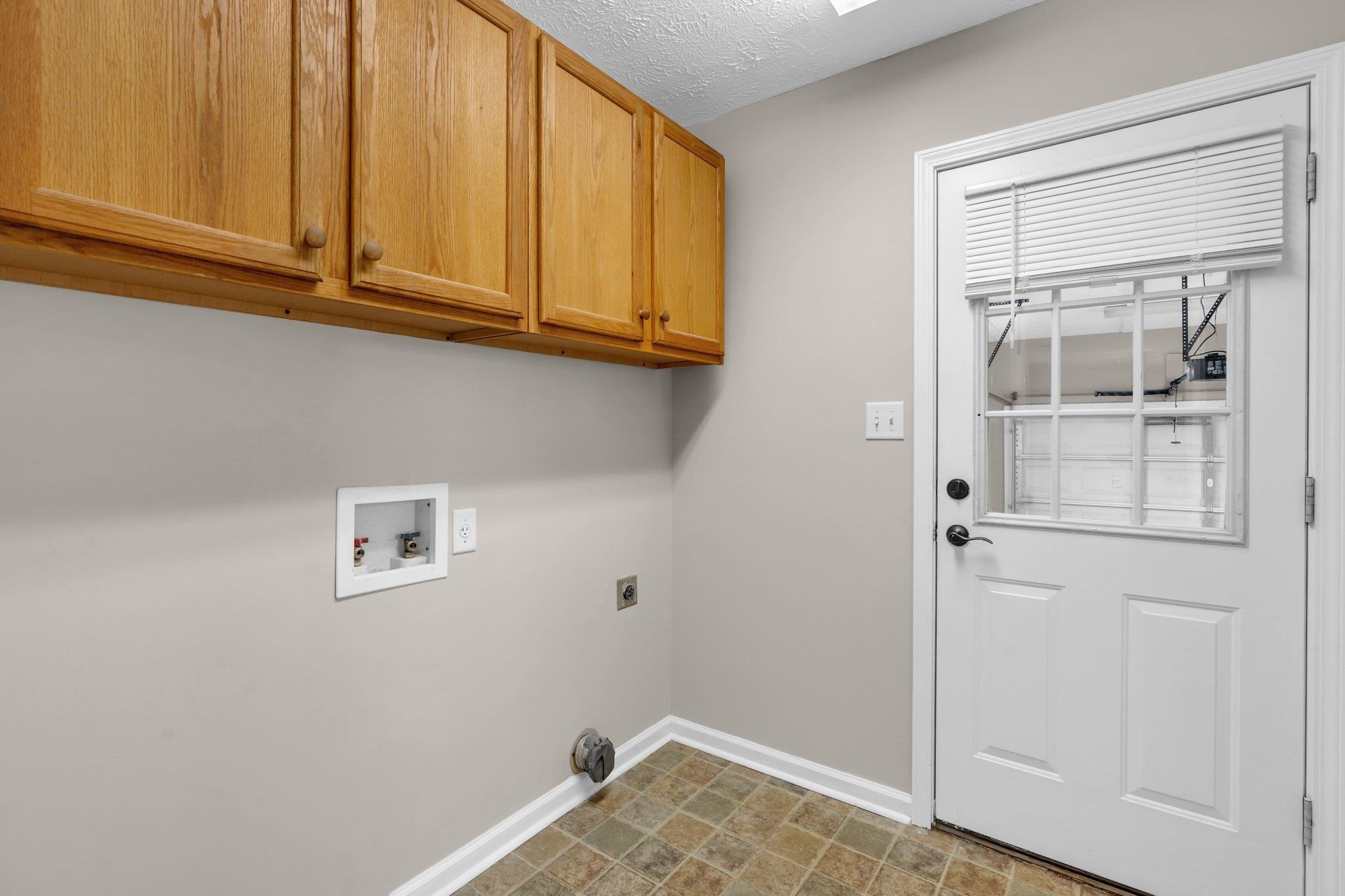 276 Mcbroom Road Henning, TN 38041 - Photo 14 of 36 Laundry room with a textured ceiling, cabinets, electric dryer hookup, and washer hookup includes 1/2 bath and hot water heater