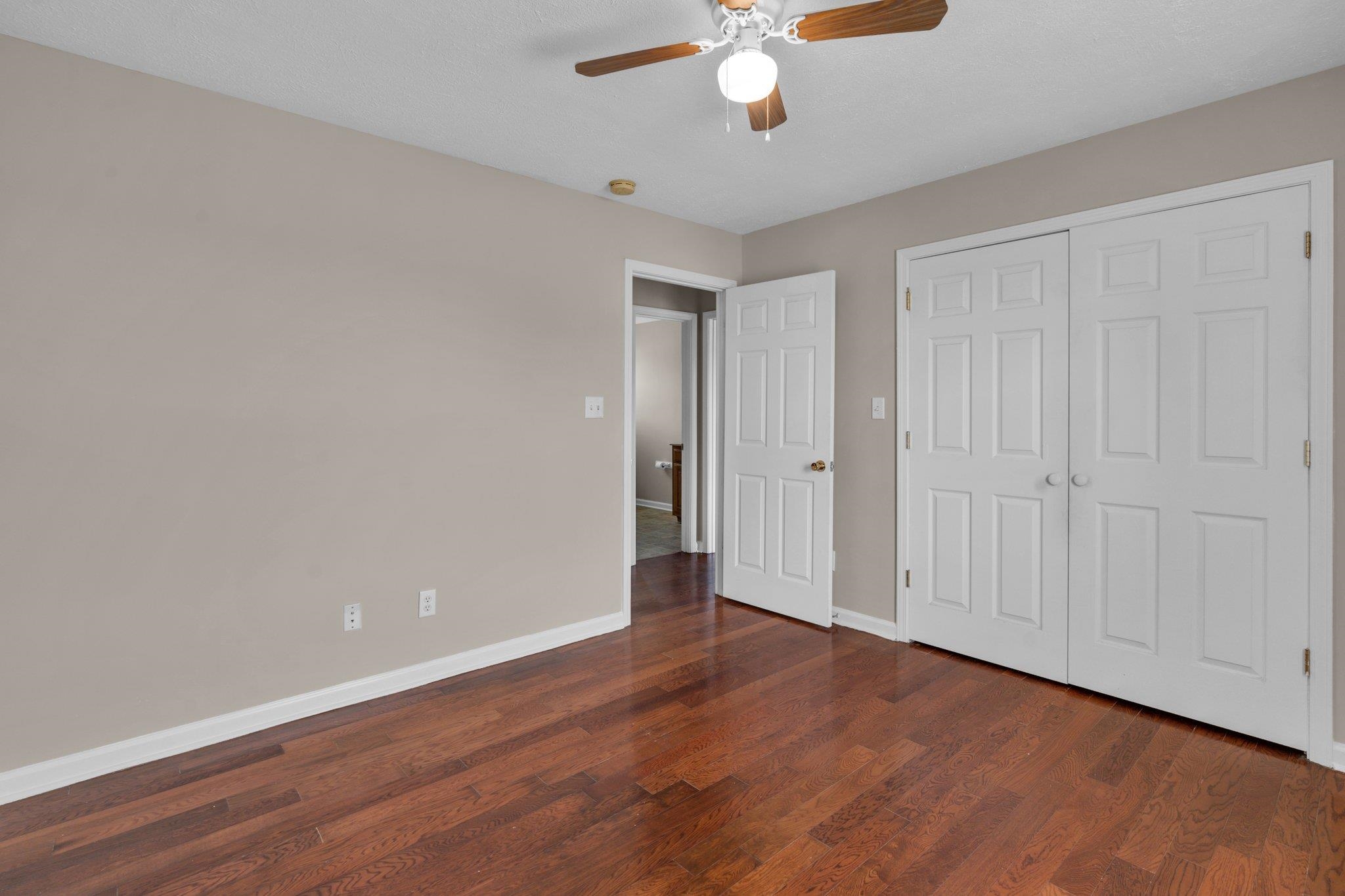 276 Mcbroom Road Henning, TN 38041 - Photo 21 of 36 Unfurnished bedroom featuring dark wood-type flooring, ceiling fan, and a closet