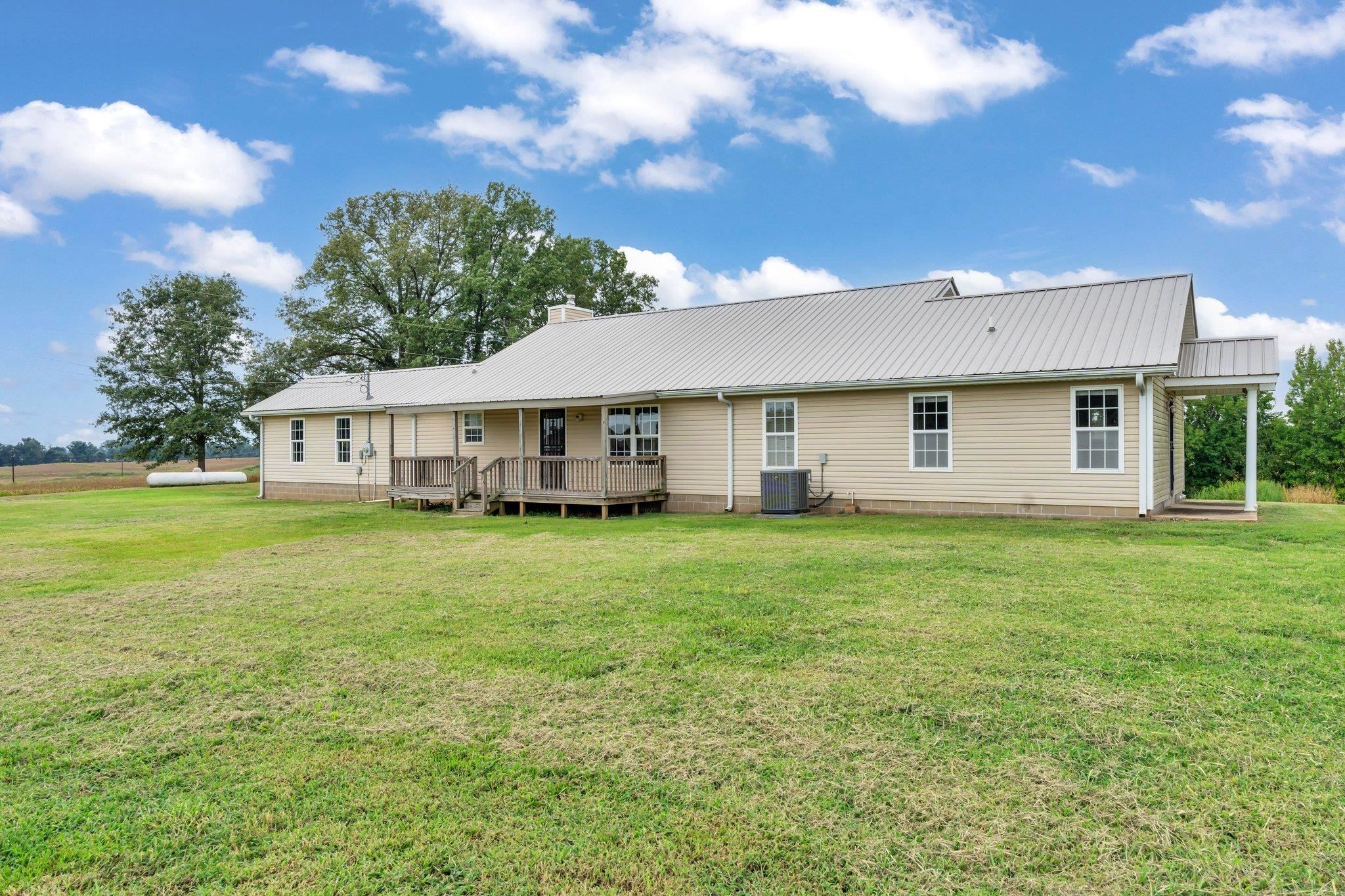 276 Mcbroom Road Henning, TN 38041 - Photo 28 of 36 Back of property with central air condition unit, a lawn, and a deck