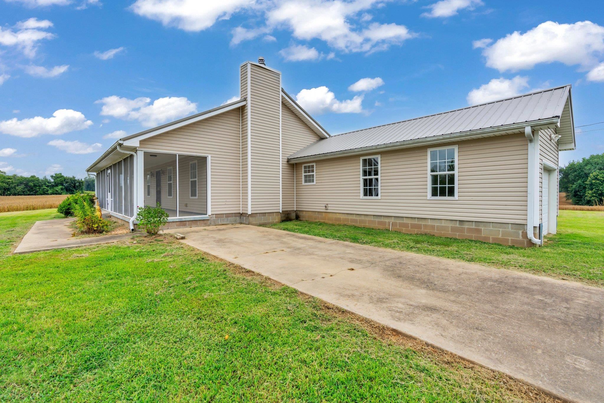 276 Mcbroom Road Henning, TN 38041 - Photo 5 of 36 View of front facade with a garage, a front yard, and a sunroom