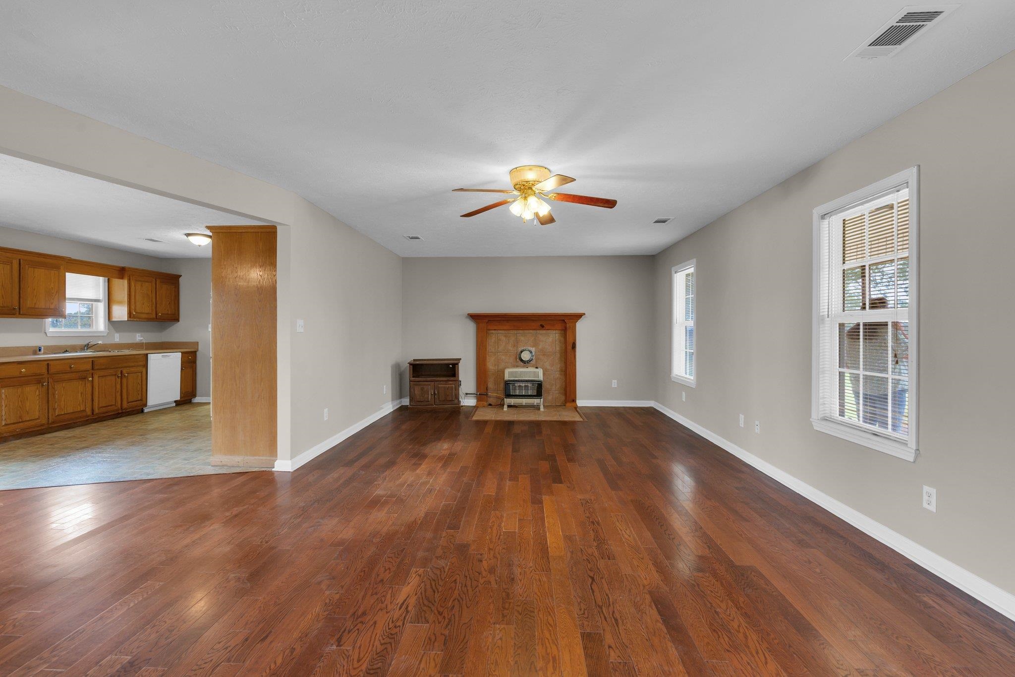 276 Mcbroom Road Henning, TN 38041 - Photo 7 of 36 Unfurnished living room featuring a healthy amount of sunlight, hardwood / wood-style floors, and ceiling fan