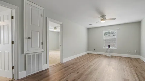 an empty room with wooden floor and windows