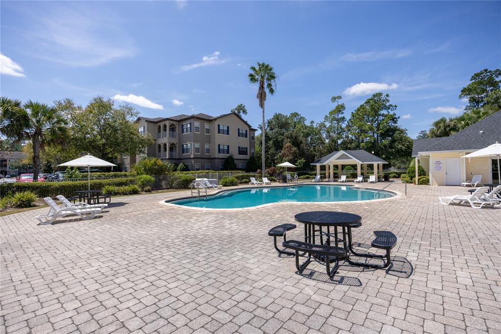 4872 Northwest 42nd Road, Unit 105 Gainesville, FL 32606 - Photo 32 of 38 a view of a patio with a table and chairs under an umbrella
