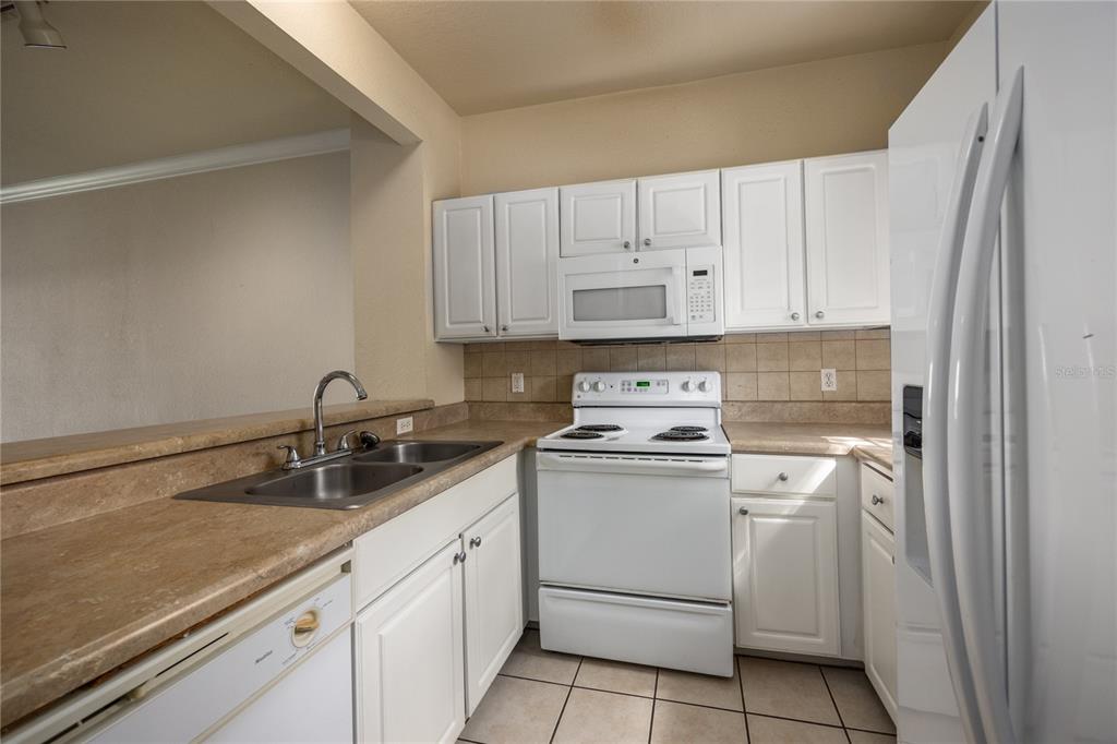 4872 Northwest 42nd Road, Unit 105 Gainesville, FL 32606 - Photo 7 of 38 a view of a kitchen with white cabinets