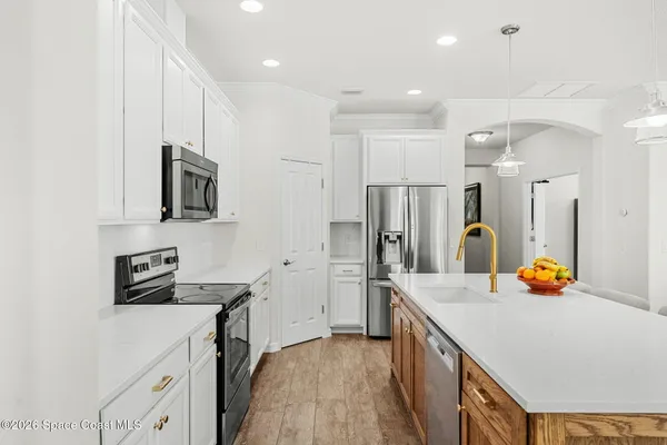 a kitchen with a sink a counter top space and stainless steel appliances