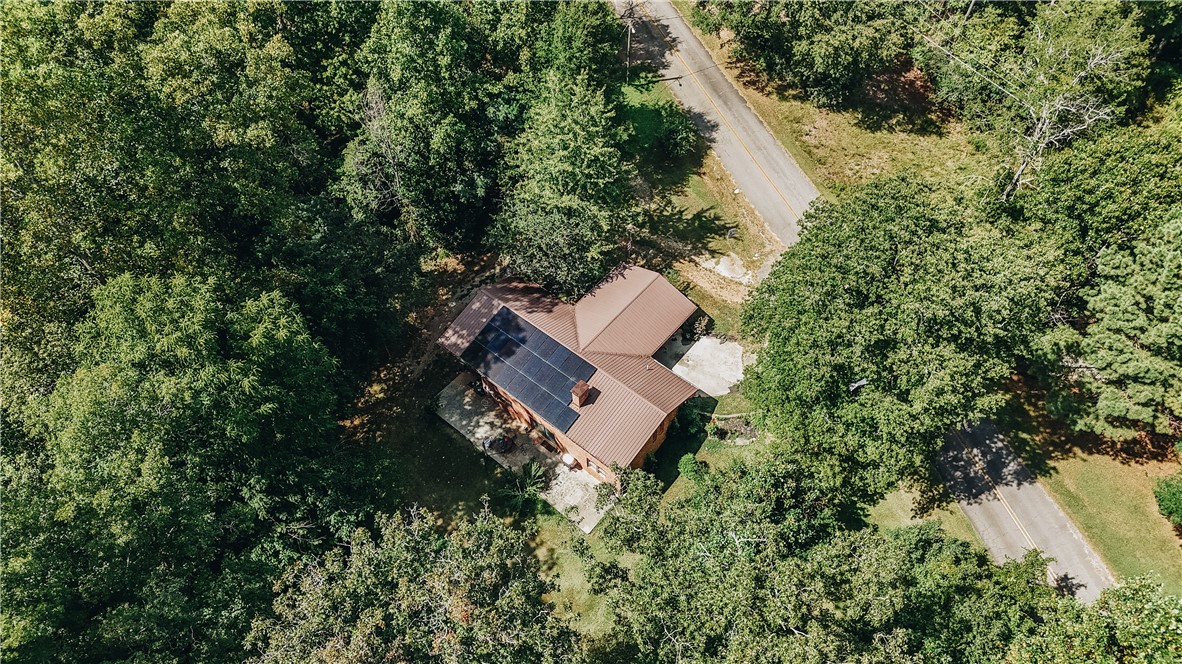 707 Campbell Town Road Walhalla, SC 29691 - Photo 43 of 44 Mature trees frame a metal roof fitted with solar panels in this secluded setting.