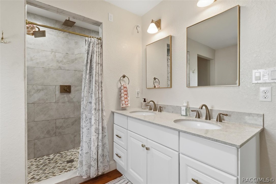 4099 West Ridge Court Dunnellon, FL 34433 - Photo 29 of 49 Master bathroom features Wood cabinets with dual sinks with quartz counters & nice lighting and mirrors. Oversized, tiled walk in shower and wait until you see the Tub? Such a pleasure to enjoy this private and personal space.