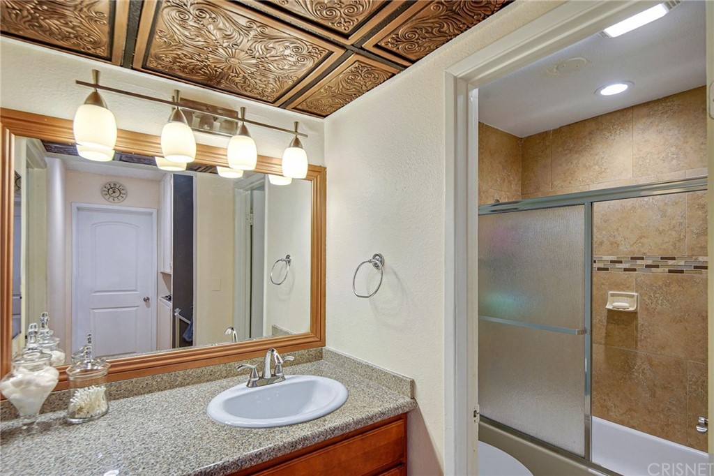 7320 Lennox Avenue, Unit H1 Van Nuys, CA 91405 - Photo 14 of 20 a bathroom with a granite countertop sink a mirror and shower