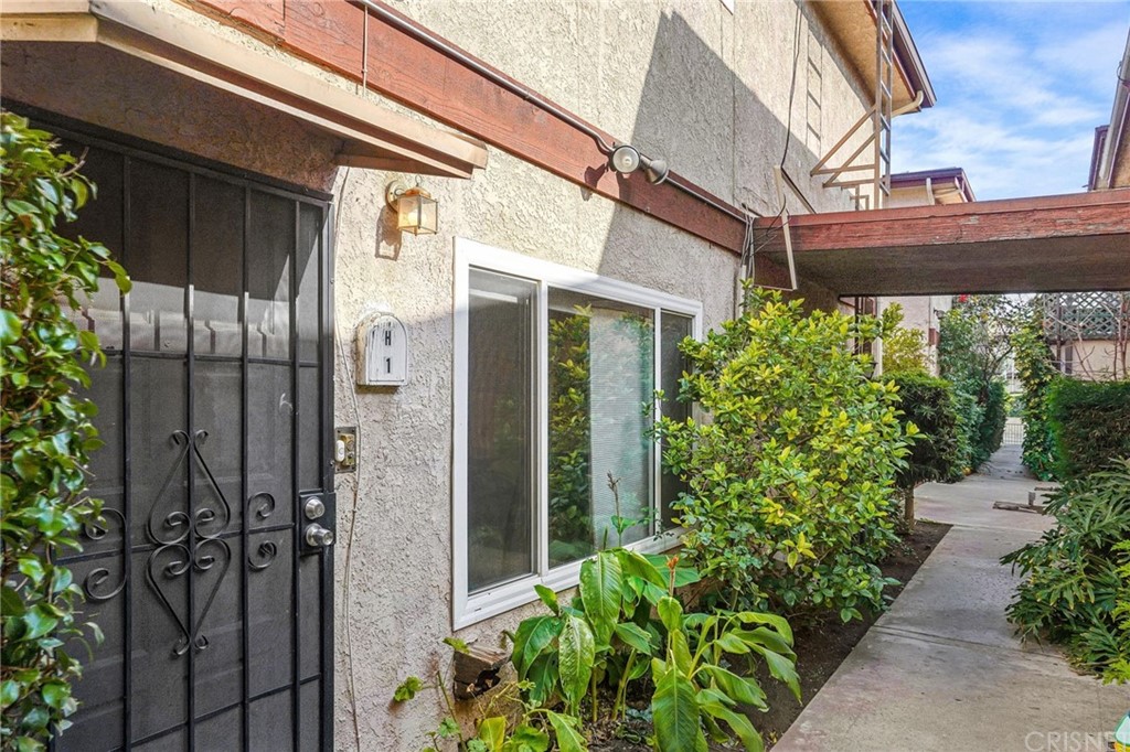 7320 Lennox Avenue, Unit H1 Van Nuys, CA 91405 - Photo 19 of 20 a view of a building with a potted plant and a window