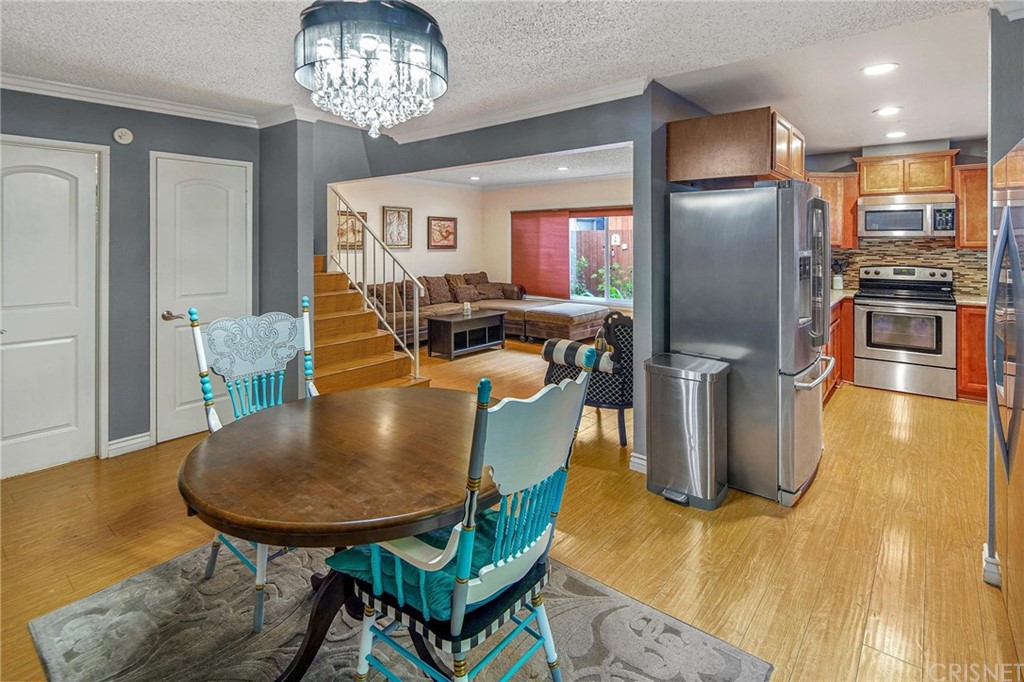 7320 Lennox Avenue, Unit H1 Van Nuys, CA 91405 - Photo 2 of 20 a view of a dining room with furniture a chandelier and wooden floor