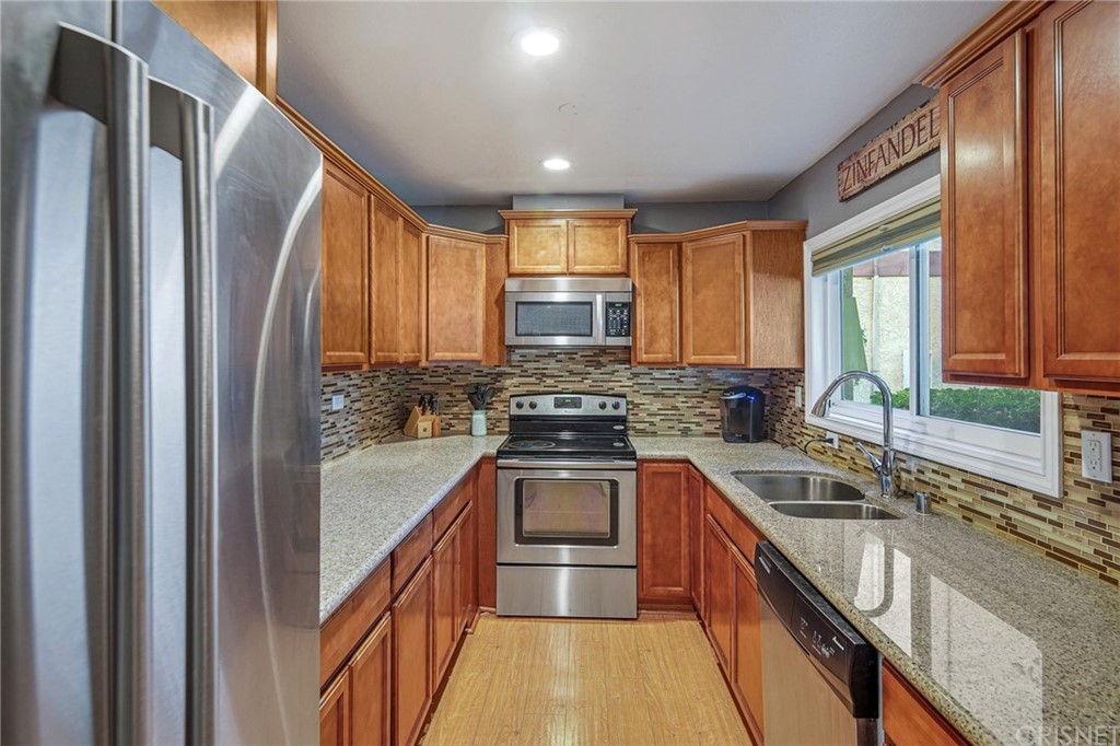 7320 Lennox Avenue, Unit H1 Van Nuys, CA 91405 - Photo 3 of 20 a kitchen with stainless steel appliances granite countertop a sink a stove and a refrigerator