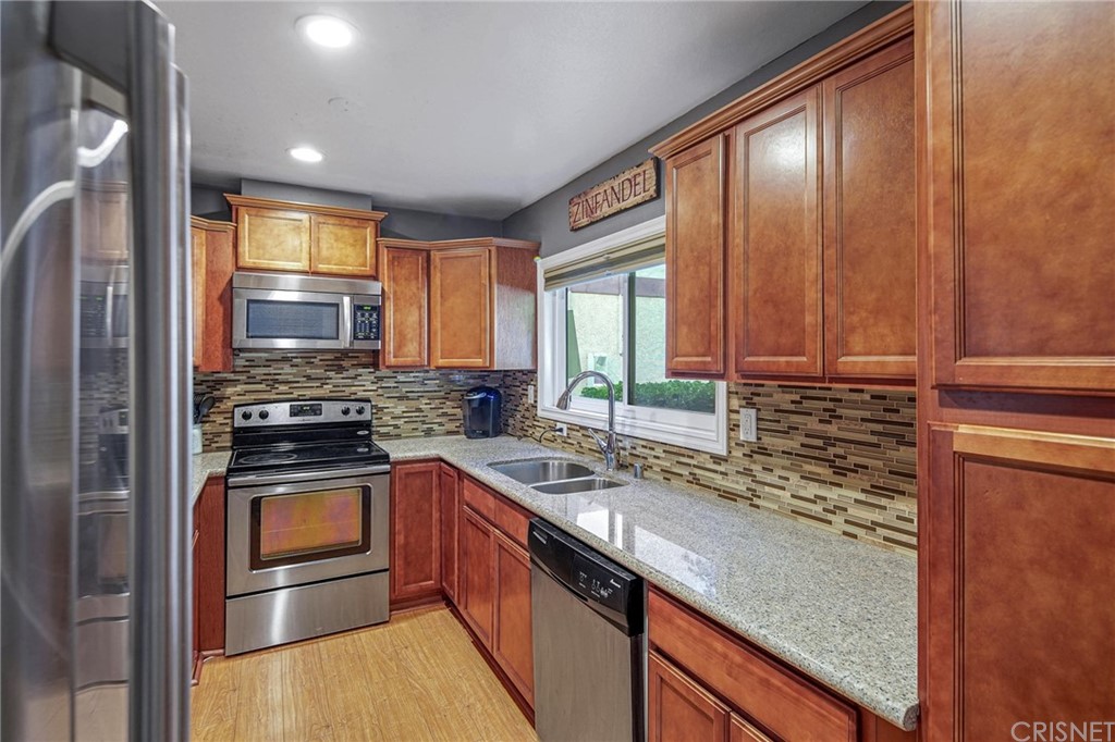 7320 Lennox Avenue, Unit H1 Van Nuys, CA 91405 - Photo 4 of 20 a kitchen with stainless steel appliances granite countertop a sink stove and cabinets
