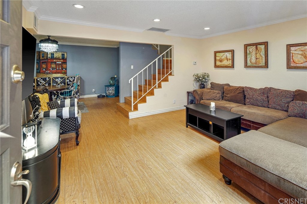 7320 Lennox Avenue, Unit H1 Van Nuys, CA 91405 - Photo 5 of 20 a living room with couches and a dining table with wooden floor