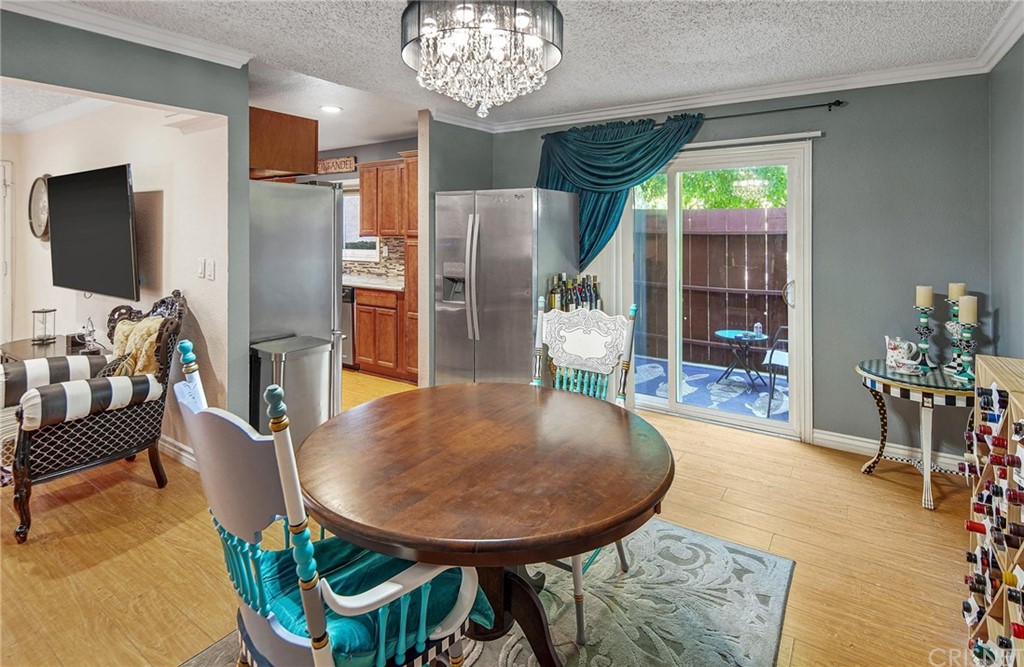 7320 Lennox Avenue, Unit H1 Van Nuys, CA 91405 - Photo 9 of 20 a view of a dining room with furniture a chandelier and wooden floor