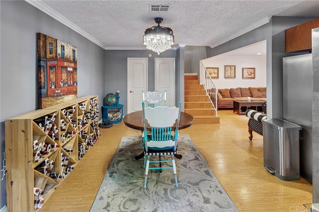 7320 Lennox Avenue, Unit H1 Van Nuys, CA 91405 - Photo 10 of 20 a dining room with furniture a chandelier and wooden floor