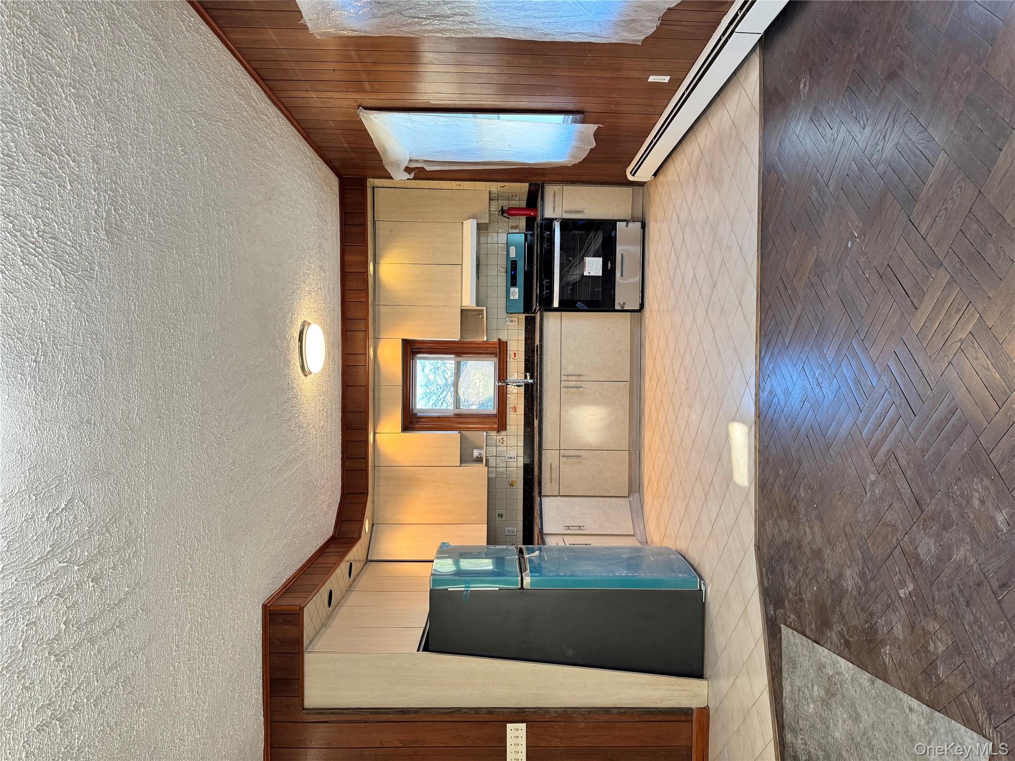259-07 147th Road Queens, NY 11422 - Photo 2 of 27 Kitchen featuring dark countertops, a sink, fridge, wood walls, and stove