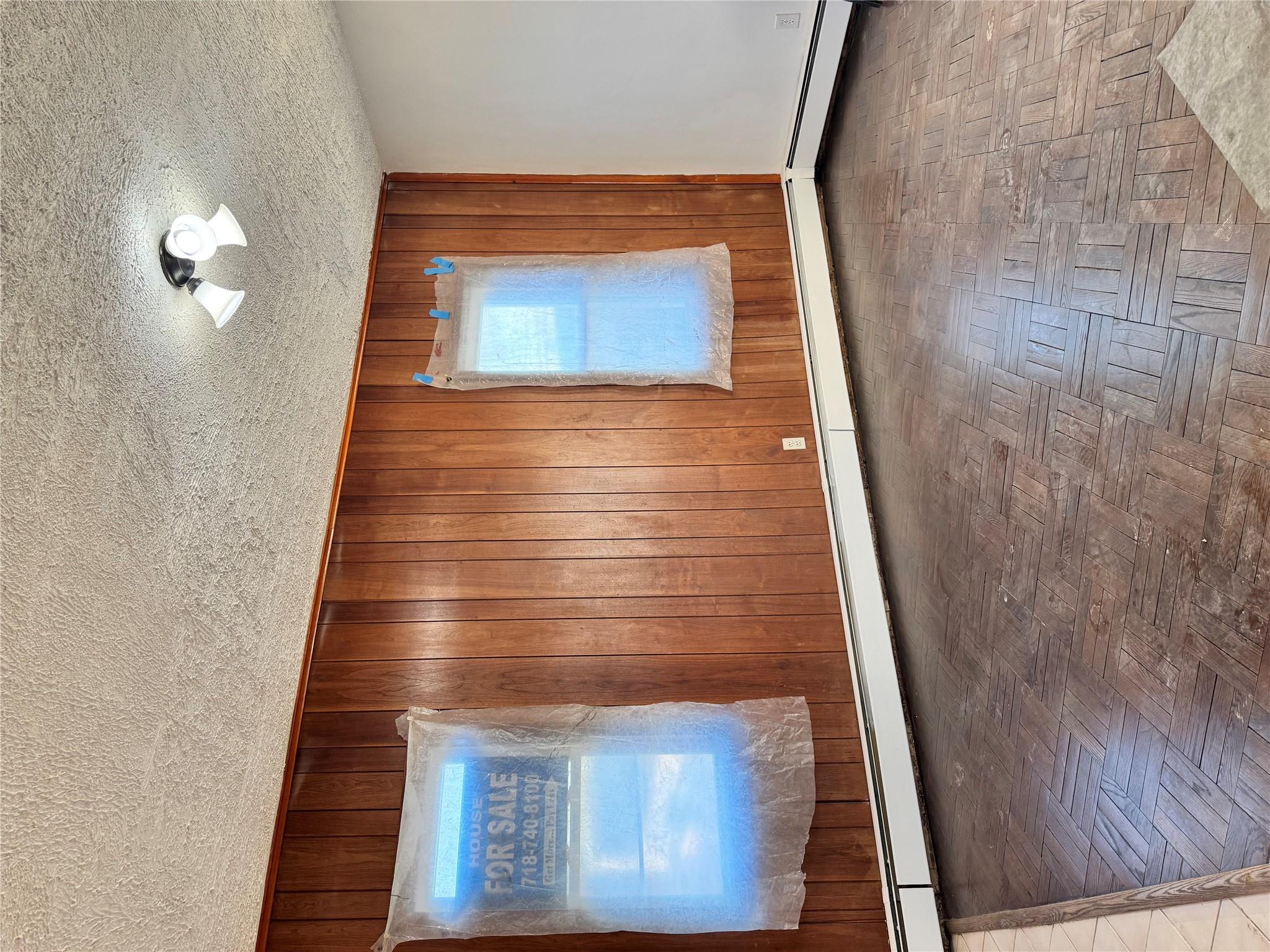 259-07 147th Road Queens, NY 11422 - Photo 3 of 24 Spare room with a baseboard heating unit, wooden walls, and a textured ceiling