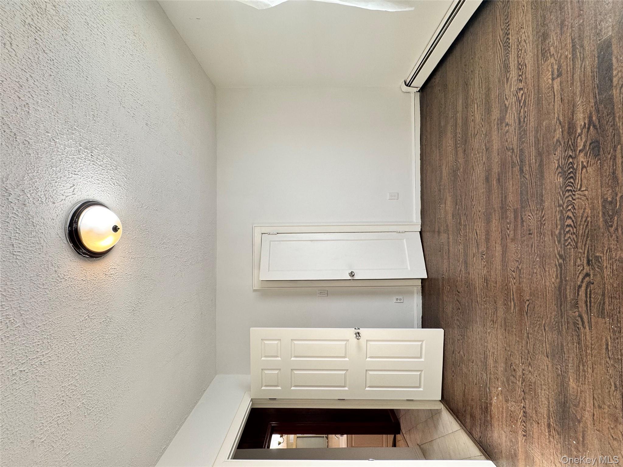 259-07 147th Road Queens, NY 11422 - Photo 4 of 27 1st floor bedroom with baseboards, dark wood-style flooring, and a textured ceiling