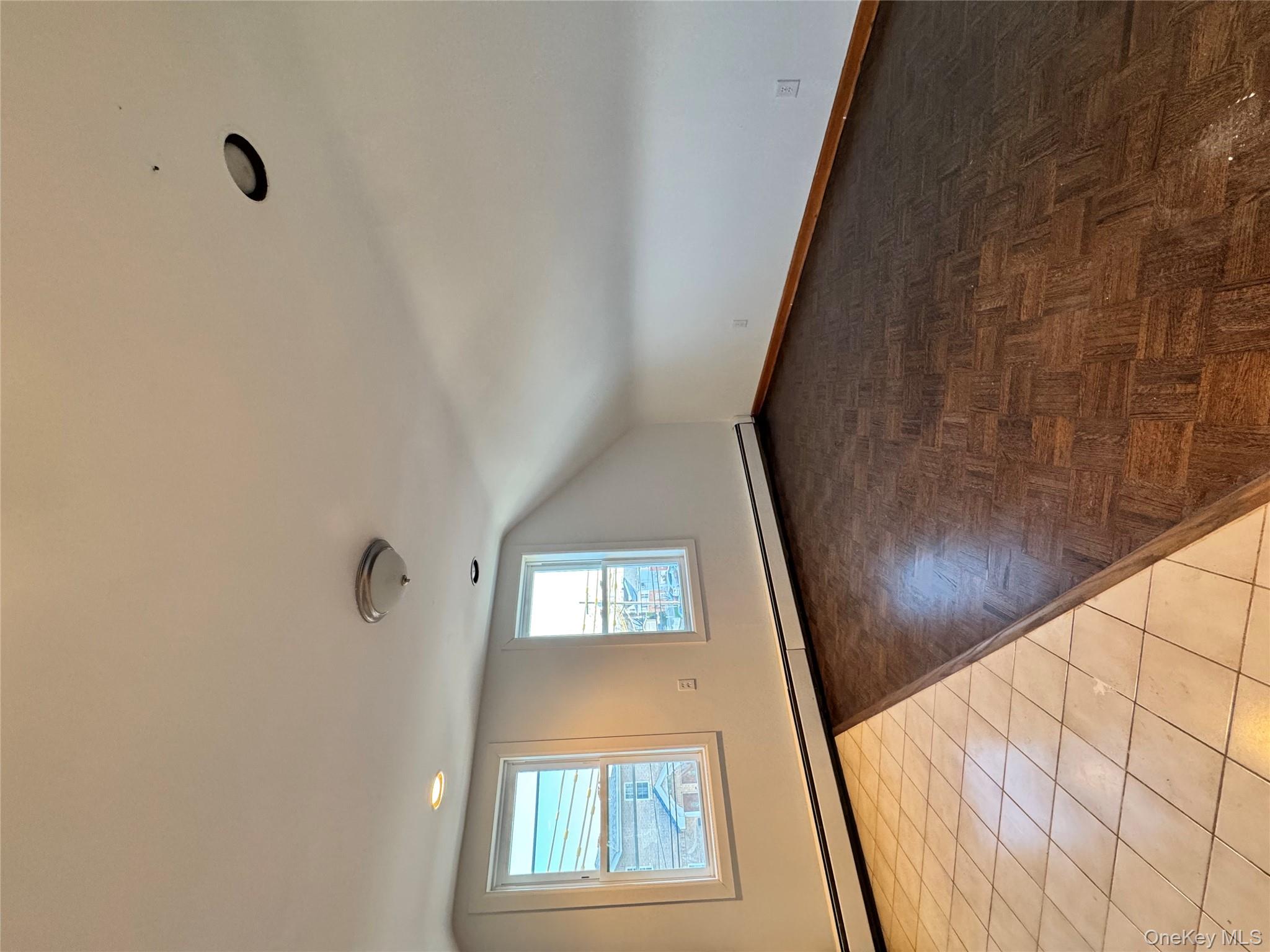 259-07 147th Road Queens, NY 11422 - Photo 9 of 27 Bonus room with a baseboard heating unit, vaulted ceiling, and baseboards