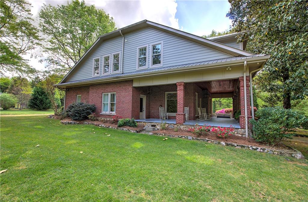 421 Boulevard Heights Calhoun, GA 30701 - Photo 14 of 96 a front view of a house with a garden and patio