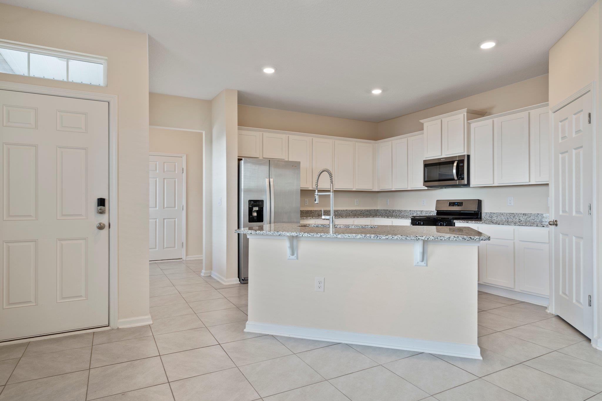 553 Coastline Way Street St. Augustine, FL 32092 - Photo 5 of 35 a kitchen with stainless steel appliances granite countertop a refrigerator stove a sink and a microwave