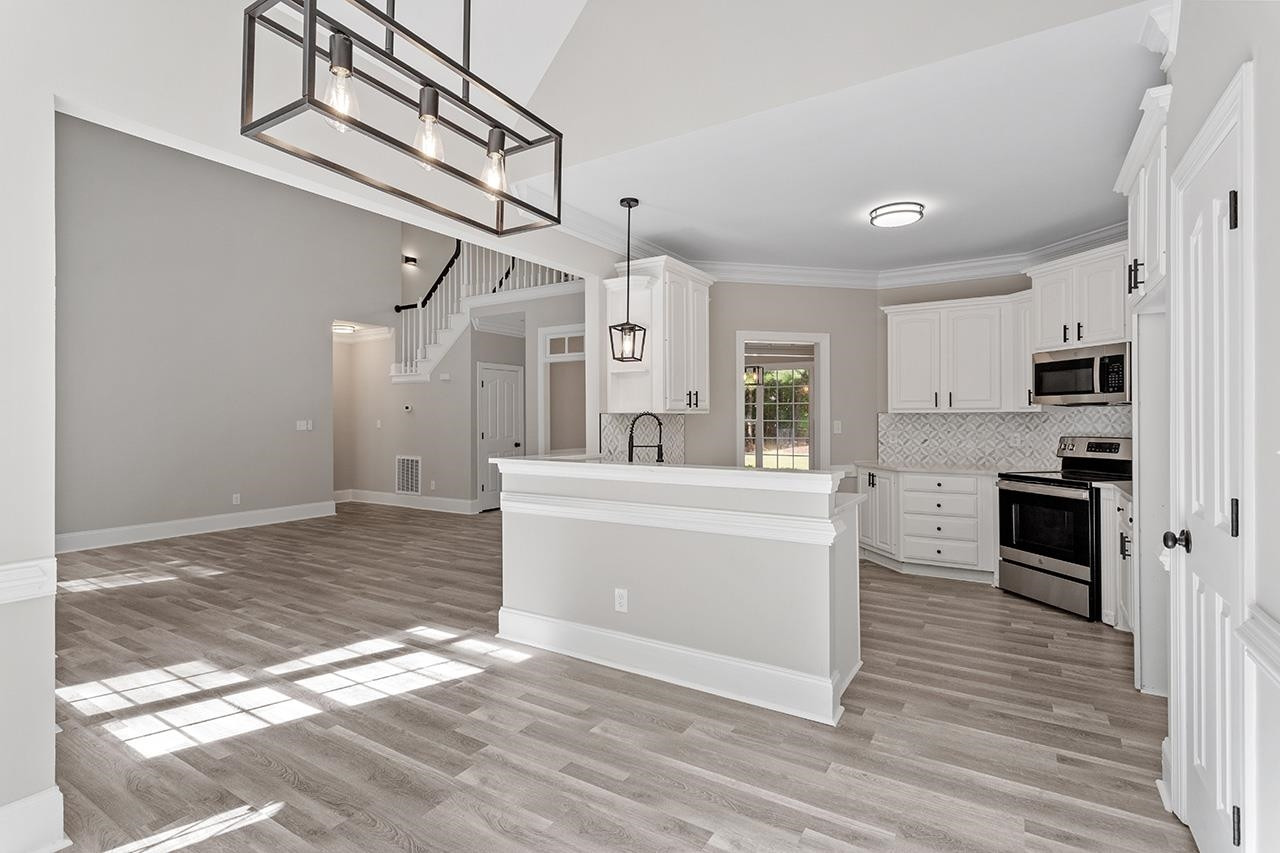 170 Fleming Forest Drive Youngsville, NC 27596 - Photo 12 of 42 a large white kitchen with a stove a refrigerator and a sink