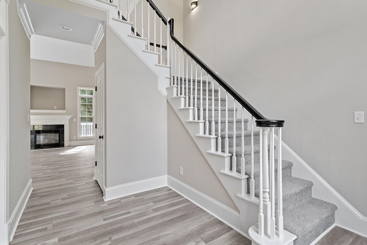 170 Fleming Forest Drive Youngsville, NC 27596 - Photo 20 of 42 a view of staircase with wooden floor and fireplace