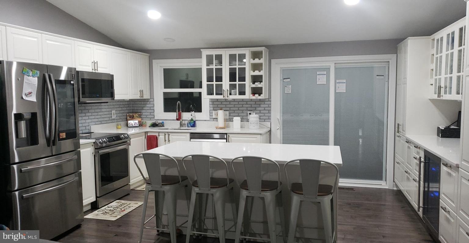 1385 Rollinghouse Drive Frederick, MD 21703 - Photo 1 of 1 a kitchen with stainless steel appliances granite countertop a refrigerator a stove top oven a sink dishwasher and wooden cabinets