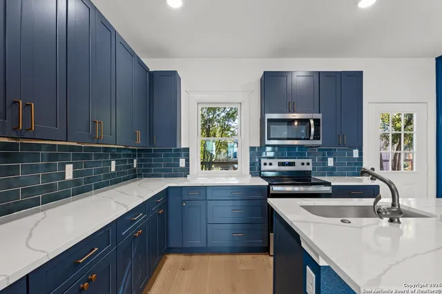 a kitchen with a sink a stove and cabinets