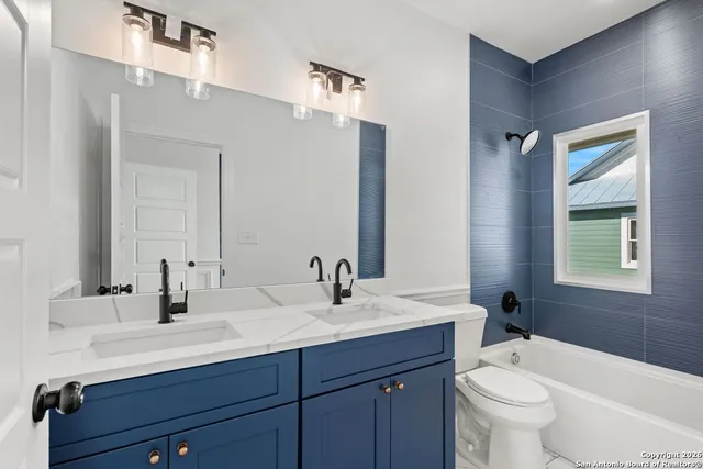 a bathroom with double sink and a mirror