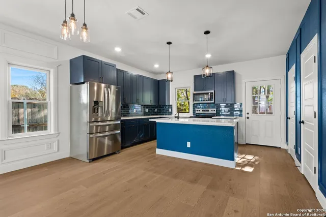 a kitchen with stainless steel appliances kitchen island granite countertop a refrigerator stove and kitchen island