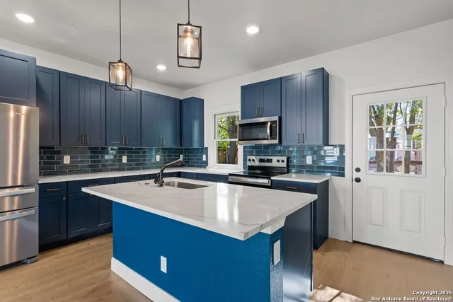 a kitchen with a sink a stove a refrigerator cabinets and a center island