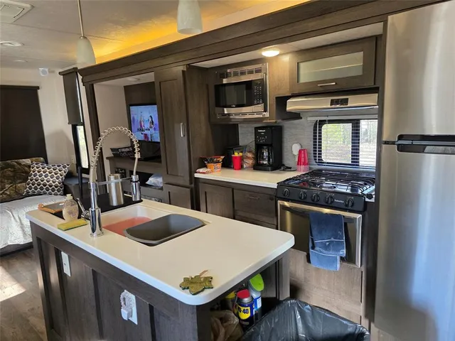 a kitchen with a stove a sink and a refrigerator