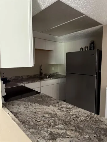 a kitchen with a refrigerator and a sink