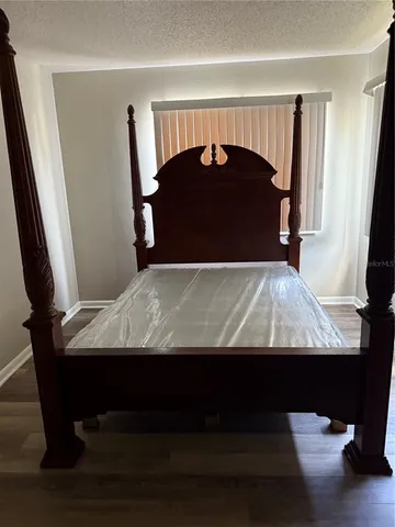 a bed sitting in a bedroom next to a window