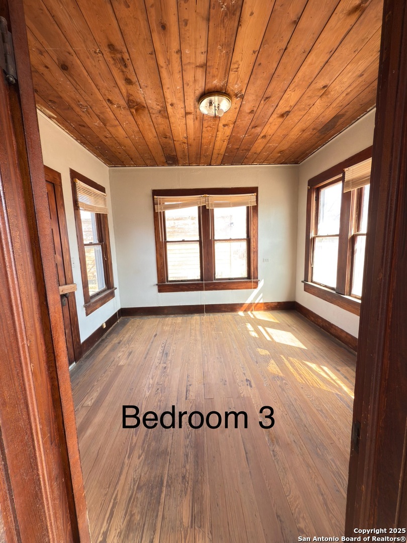 505 East Rio Grande Street Pearsall, TX 78061 - Photo 11 of 12 wooden floor in an empty room with a window