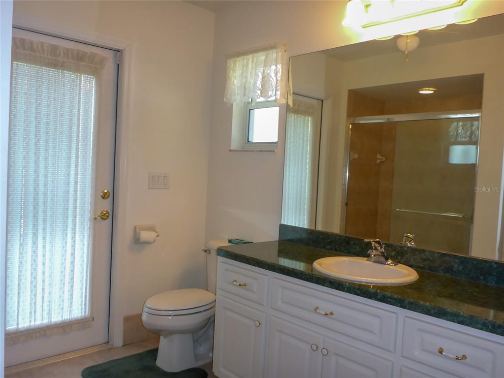 12271 Centralia Road Weeki Wachee, FL 34614 - Photo 16 of 36 a bathroom with a granite countertop sink toilet a mirror and shower