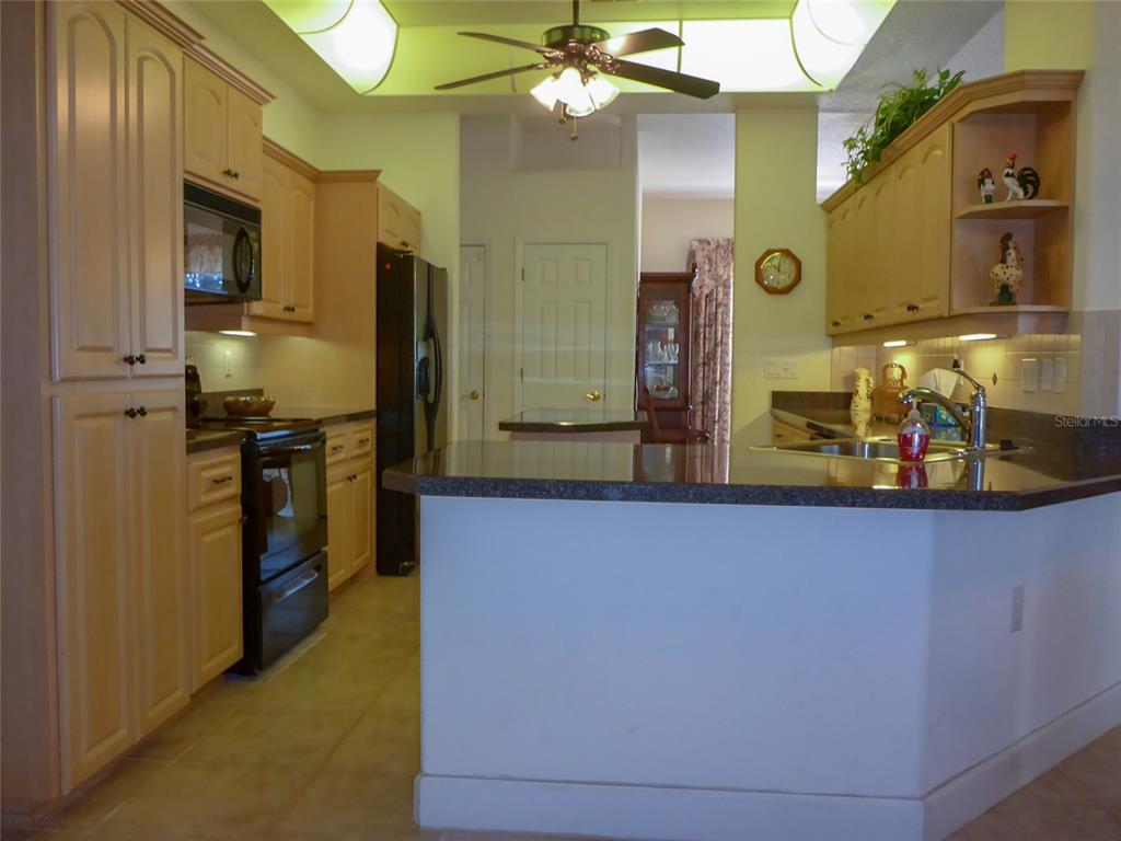 12271 Centralia Road Weeki Wachee, FL 34614 - Photo 5 of 36 a kitchen with stainless steel appliances a sink a stove cabinets and a counter top space