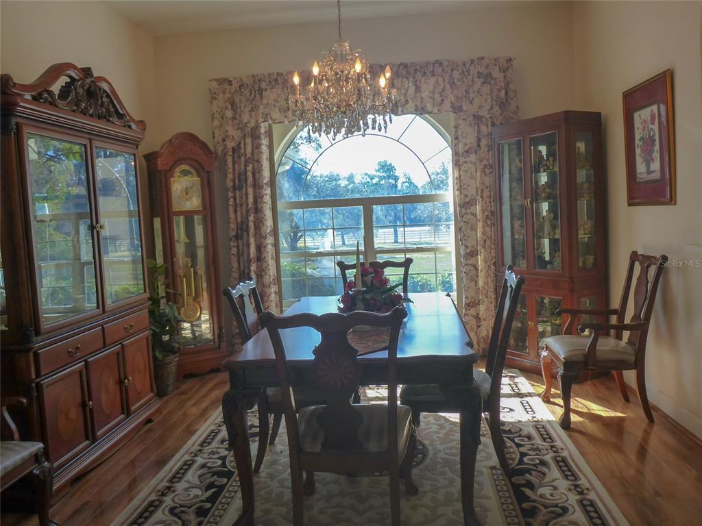 12271 Centralia Road Weeki Wachee, FL 34614 - Photo 7 of 36 a view of a dining room with furniture a chandelier and wooden floor