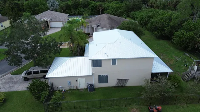 an aerial view of a house with swimming pool and patio