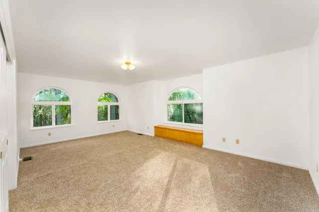 a view of a house with a yard and large trees