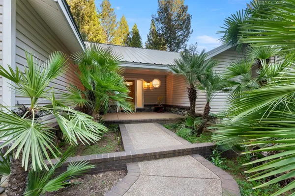 a view of a house with backyard and sitting area