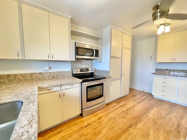 a kitchen with stainless steel appliances granite countertop a stove a sink and a microwave