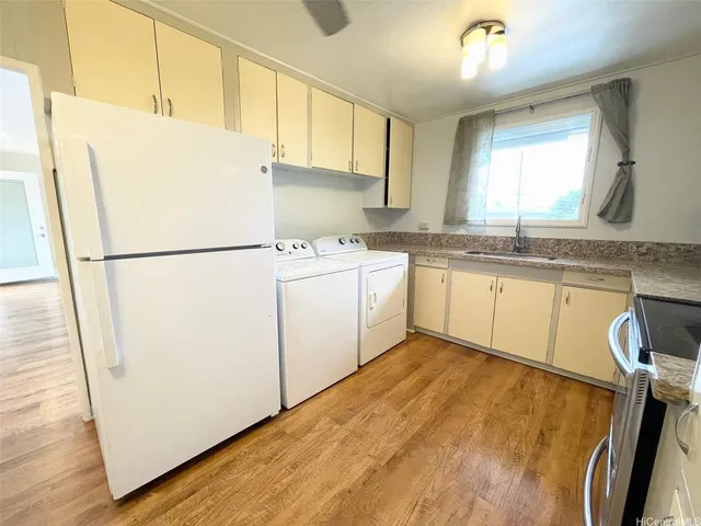 a kitchen with a sink a refrigerator a stove a microwave and cabinets
