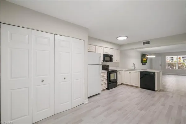 a view of a kitchen with stainless steel appliances refrigerator and cabinets