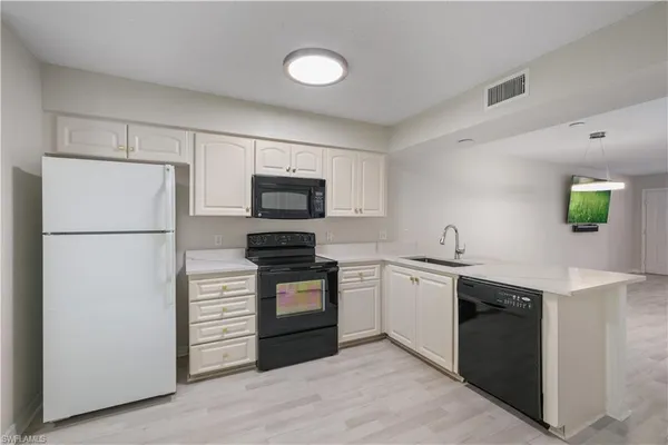a kitchen with a sink stainless steel appliances and cabinets