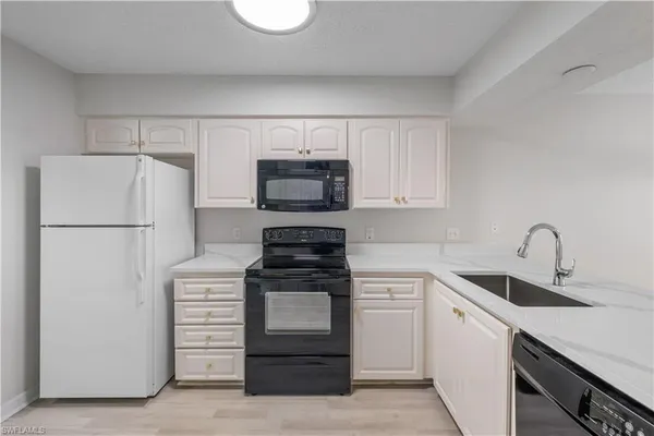 a kitchen with white cabinets and stainless steel appliances